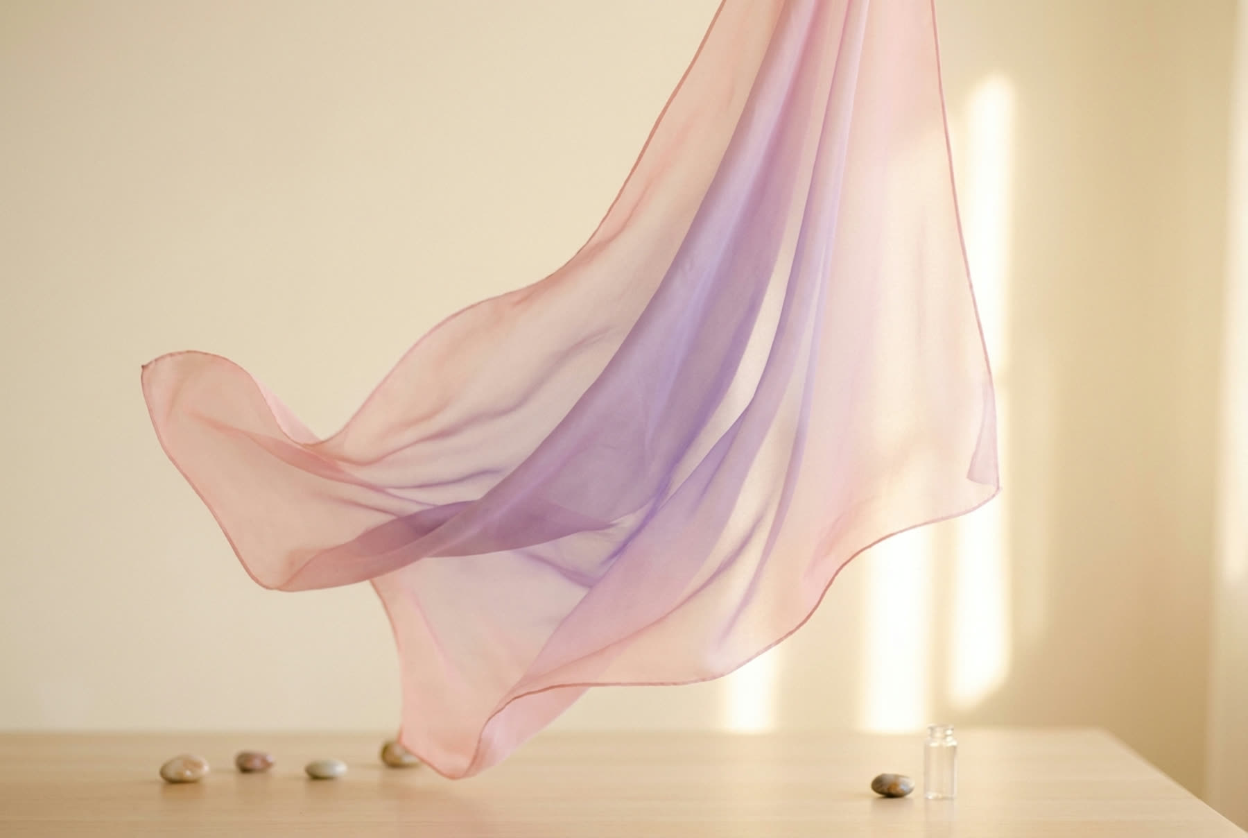 Sheer silk folding in still air, glowing from blush to lavender